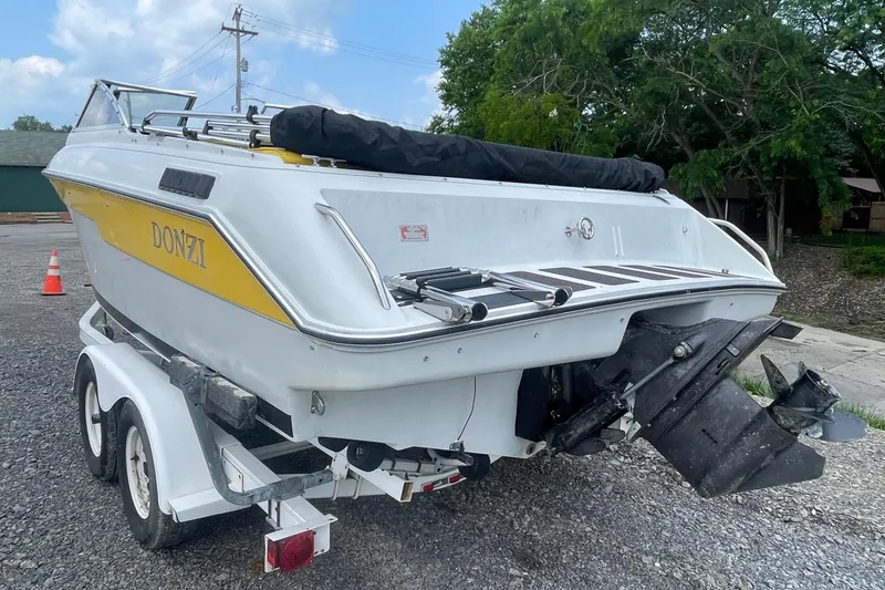 Slide: The Image of 1988 Donzi Open Bow boat on trailer, featuring yellow accents and outboard motor. - 2