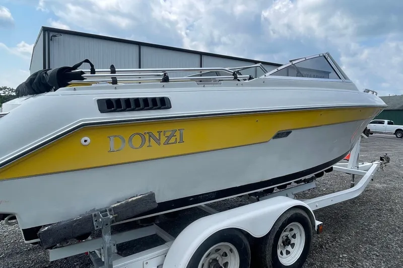 Slide: The Image of 1988 Donzi Open Bow boat with yellow accents on a trailer, parked outdoors. - 4