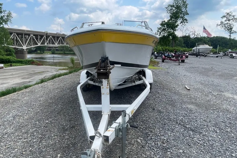Slide: The Image of 1988 Donzi Open Bow boat on trailer, parked near river and bridge. - 6