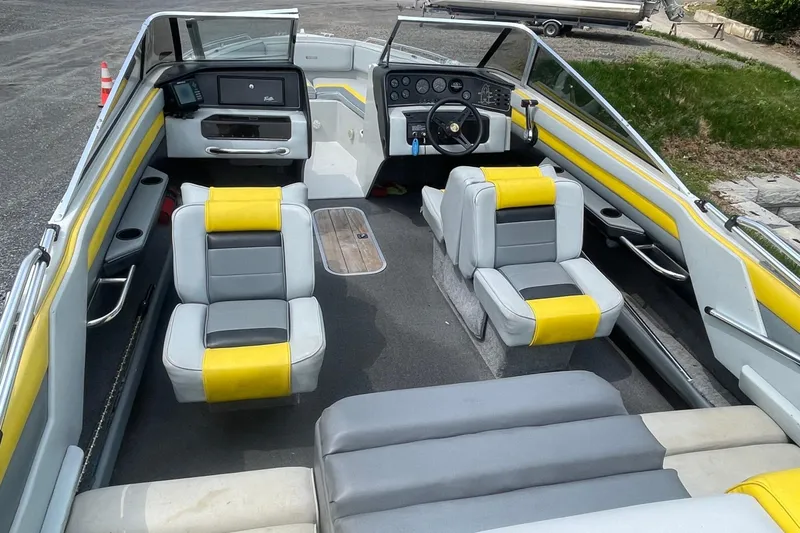Slide: The Image of 1988 Donzi Open Bow boat interior with yellow and gray seating, steering wheel, and dashboard. - 7