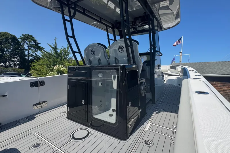 Slide: The Image of Edgewater 340CC 2025 boat interior with seating and console, docked under clear blue sky. - 16