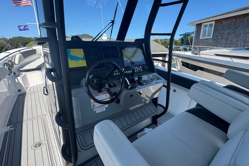 Slide: The Image of 2025 Edgewater 340CC boat dashboard with navigation screens and steering wheel. - 23