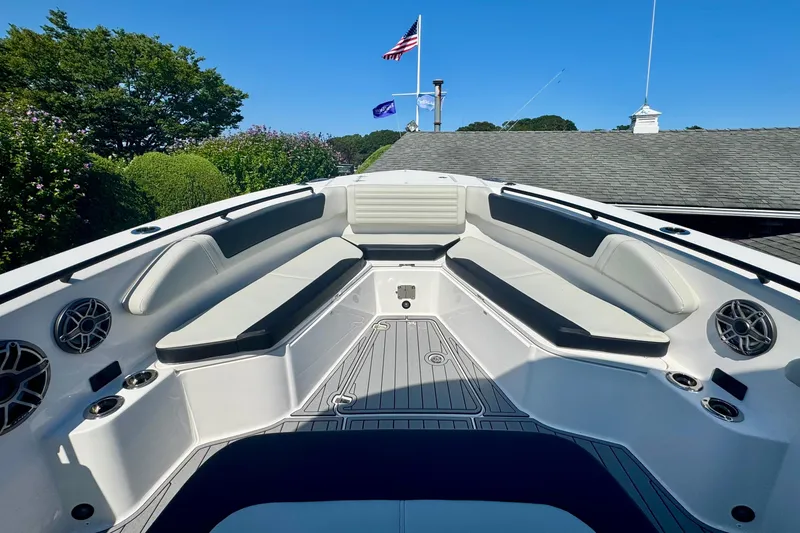 Slide: The Image of 2025 Edgewater 340CC boat interior with seating, docked under clear blue sky. - 31