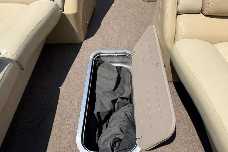 Slide: The Image of Open storage compartment on 2012 Bennington 2575 QCW I/O boat with beige seating. - 12