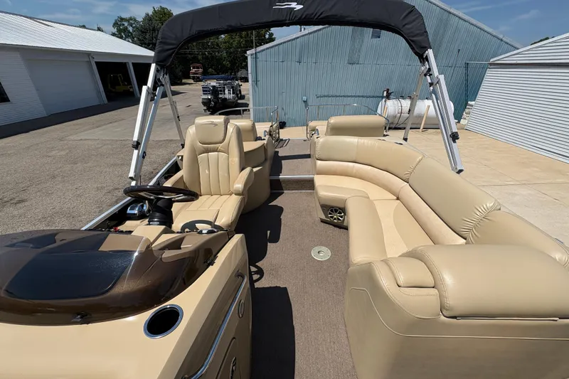 Slide: The Image of 2012 Bennington 2575 QCW I/O pontoon boat with beige seating and canopy in a marina. - 15
