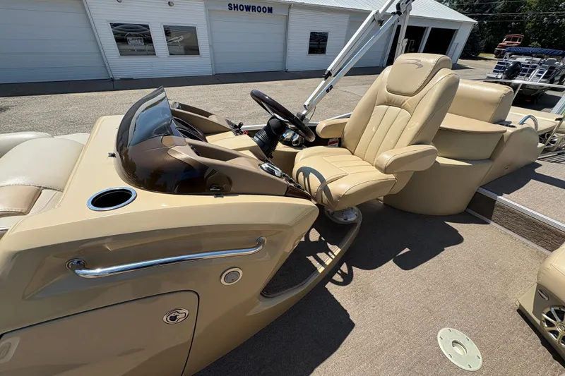 Slide: The Image of 2012 Bennington 2575 QCW I/O boat interior with beige captain's chair and dashboard. - 16