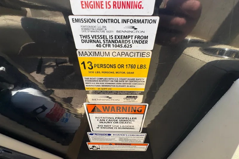 Slide: The Image of Warning labels on a 2012 Bennington 2575 QCW I/O boat, detailing capacity and safety information. - 18