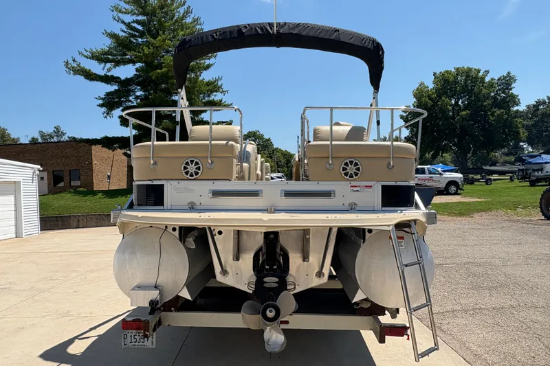 Slide: The Image of 2012 Bennington 2575 QCW I/O pontoon boat, rear view, parked outdoors. - 2