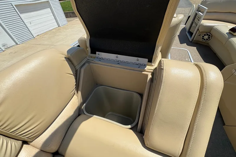 Slide: The Image of 2012 Bennington 2575 QCW I/O boat with open storage compartment and beige seating. - 20