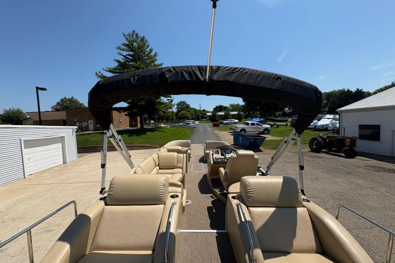 Slide: The Image of 2012 Bennington 2575 QCW I/O pontoon boat with beige seating and canopy, parked outdoors. - 25