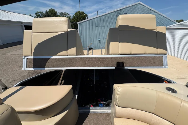 Slide: The Image of 2012 Bennington 2575 QCW I/O boat interior with beige seating and storage area. - 27