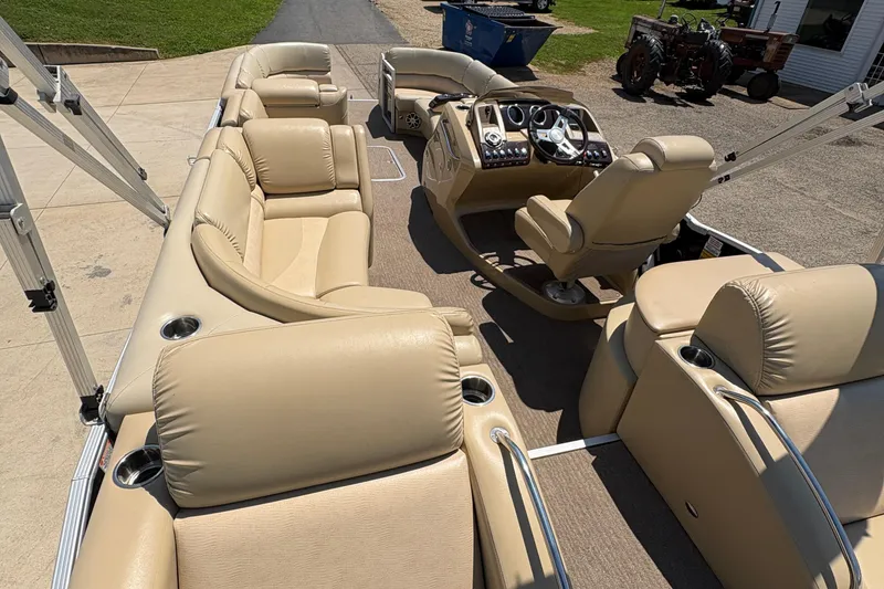 Slide: The Image of 2012 Bennington 2575 QCW I/O pontoon boat with beige leather seating and modern dashboard. - 30