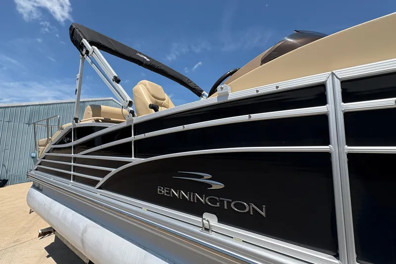 Slide: The Image of 2012 Bennington 2575 QCW I/O pontoon boat with sleek design under blue sky. - 32