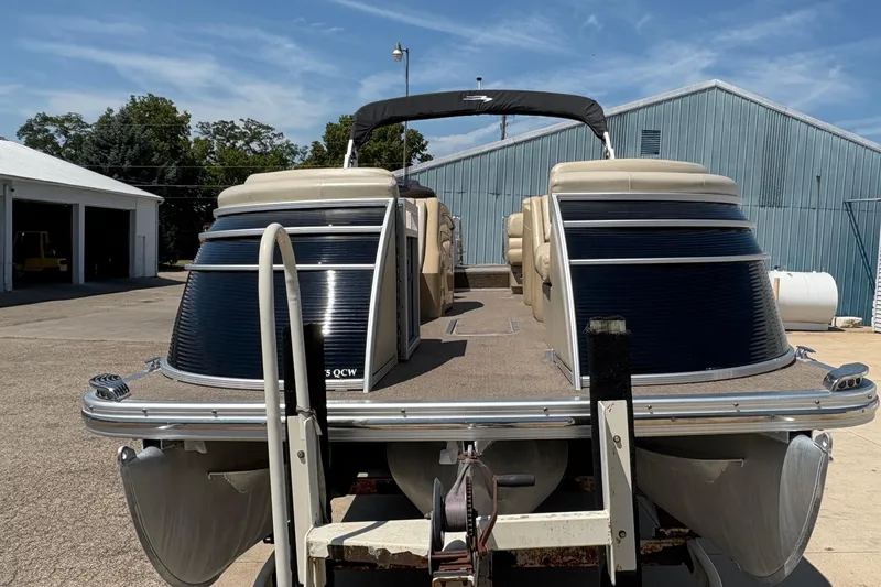 Slide: The Image of 2012 Bennington 2575 QCW I/O pontoon boat on trailer, parked outdoors. - 6