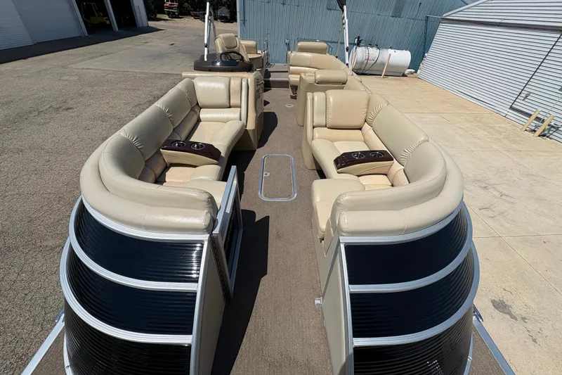 Slide: The Image of 2012 Bennington 2575 QCW I/O pontoon boat with beige seating and cup holders. - 7