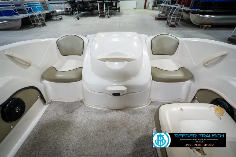 Slide: The Image of 2005 Sea Ray 180 Sport boat interior with beige seating in a garage setting. - 19