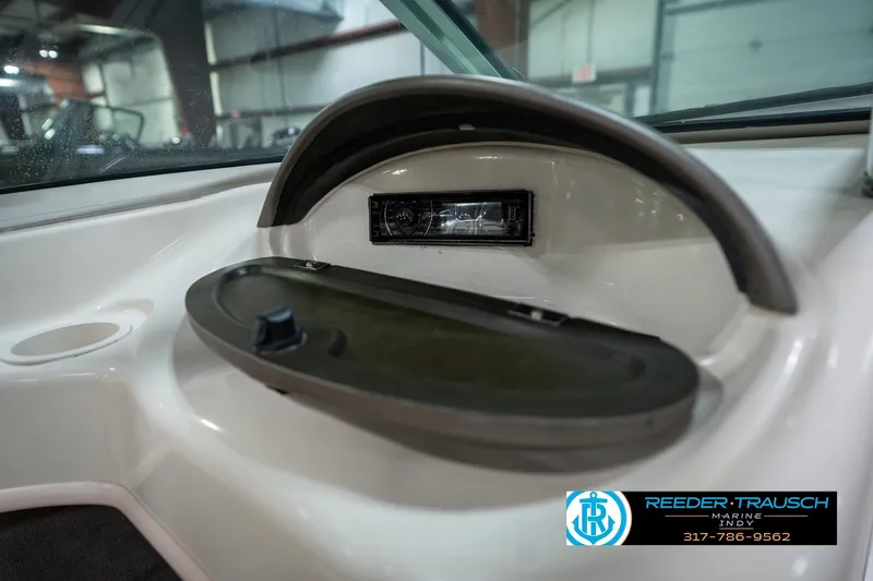 Slide: The Image of 2005 Sea Ray 180 Sport boat dashboard with storage compartment and logo. - 25