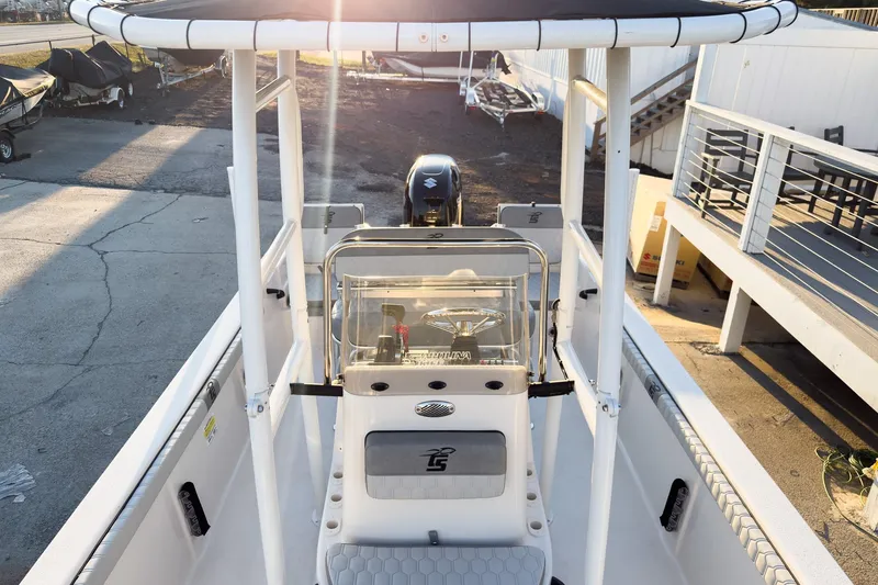 Slide: The Image of 2026 Carolina Skiff 19 LS boat with T-top and console, parked outdoors. - 13