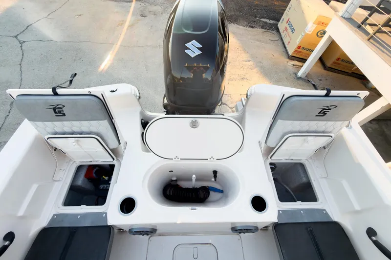 Slide: The Image of 2026 Carolina Skiff 19 LS boat interior with Suzuki engine, storage compartments, and seating. - 25