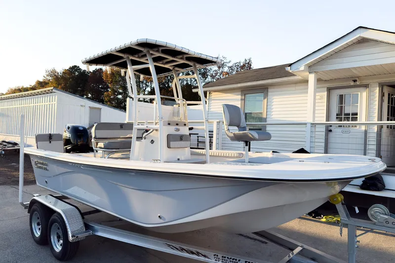 Slide: The Image of 2026 Carolina Skiff 19 LS boat on trailer, parked near white building. - 8