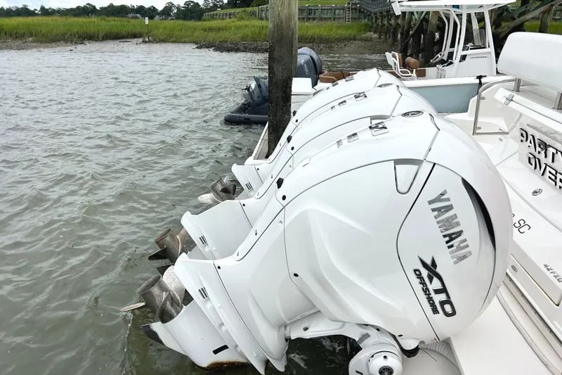 Slide: The Image of 2024 Regal 42 FXO with Yamaha XTO Offshore engines docked by the water. - 13