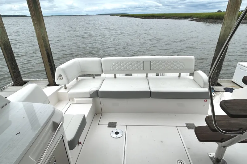 Slide: The Image of 2024 Regal 42 FXO yacht with spacious white seating area by the water. - 15