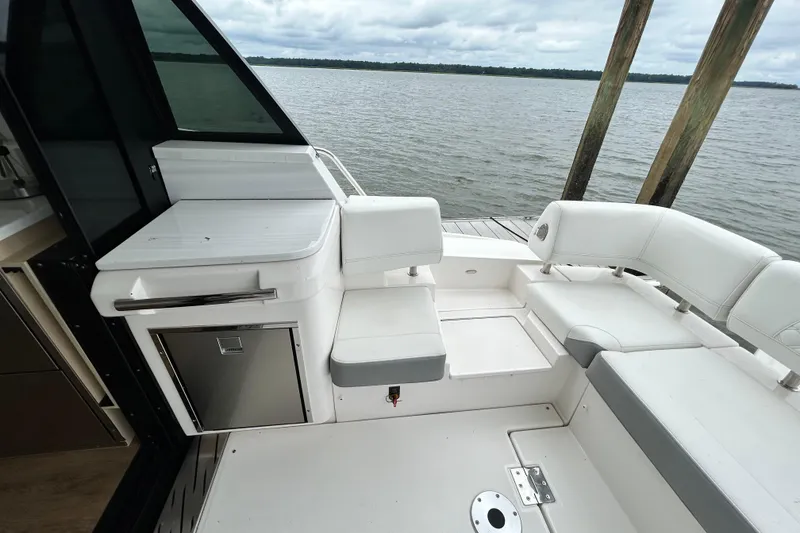 Slide: The Image of 2024 Regal 42 FXO yacht interior with white seating and water view. - 16