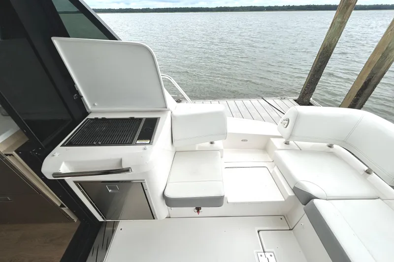 Slide: The Image of 2024 Regal 42 FXO yacht with outdoor seating and grill by the water. - 17