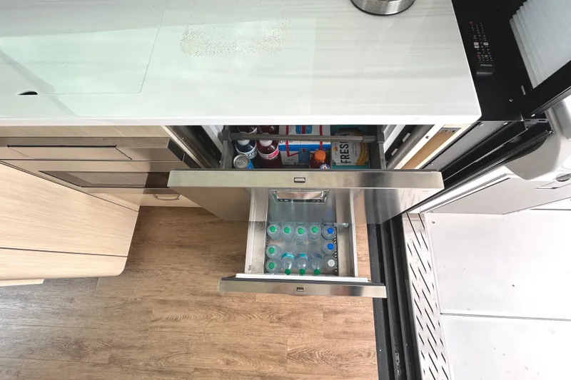 Slide: The Image of 2024 Regal 42 FXO yacht kitchen with open drawers, showcasing beverages and storage. - 22