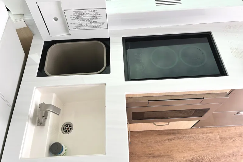 Slide: The Image of 2024 Regal 42 FXO yacht kitchen with sink, stove, and storage. - 24