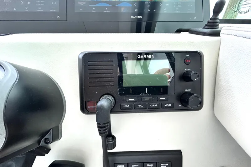 Slide: The Image of Garmin marine radio on 2024 Regal 42 FXO dashboard, featuring control knobs and display. - 30