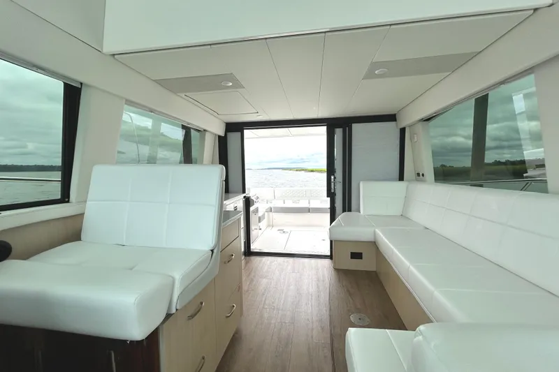 Slide: The Image of Luxurious interior of 2024 Regal 42 FXO yacht with white seating and panoramic windows. - 34