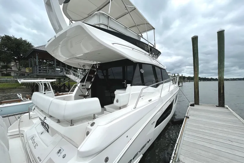Slide: The Image of 2024 Regal 42 FXO luxury yacht docked by the water on a cloudy day. - 4