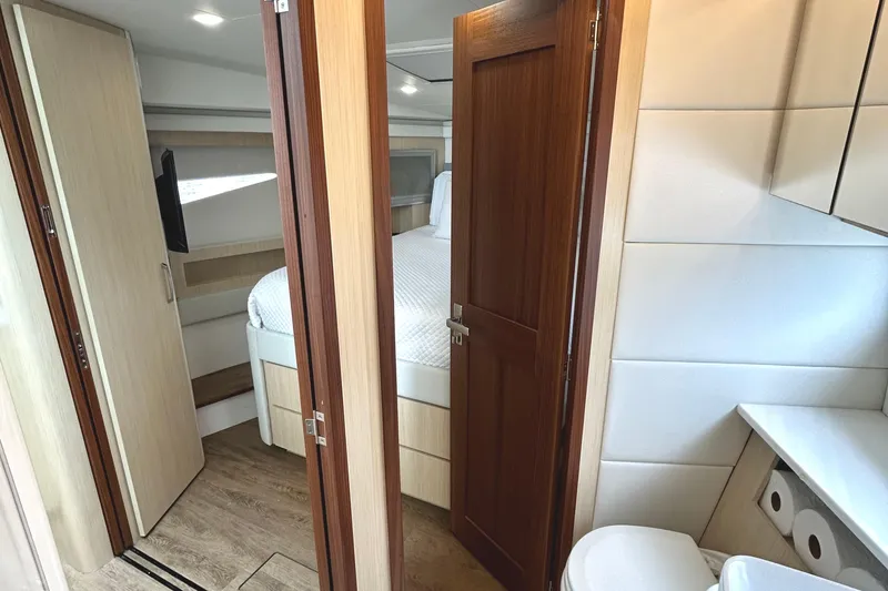 Slide: The Image of 2024 Regal 42 FXO yacht interior with bedroom, bathroom, and modern wood finishes. - 43