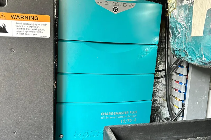 Slide: The Image of Battery charger in 2024 Regal 42 FXO boat, with safety warning label visible. - 53