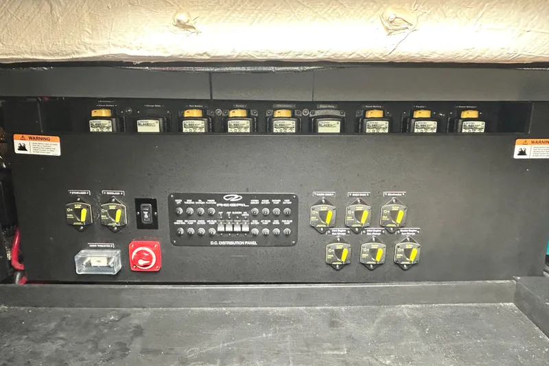 Slide: The Image of 2024 Regal 42 FXO electrical distribution panel with switches and warning labels. - 54