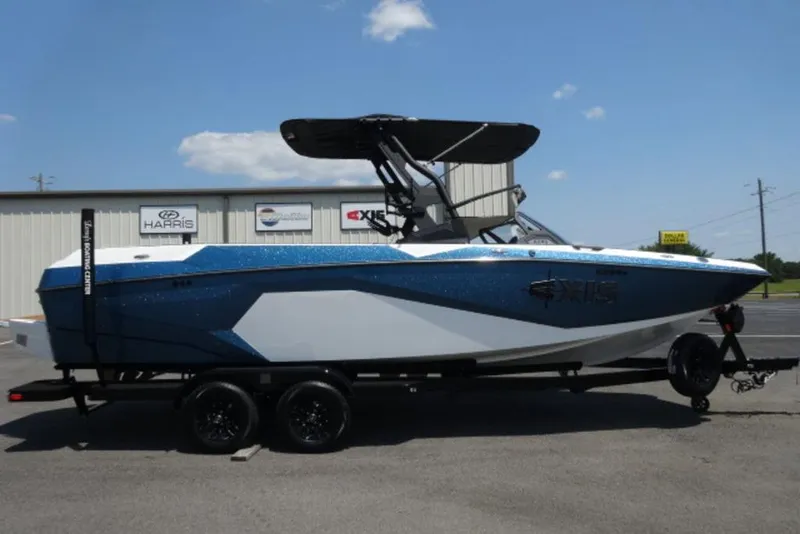 The Image of 2025 Axis A245 boat on trailer, blue and white design, parked outdoors. - 0