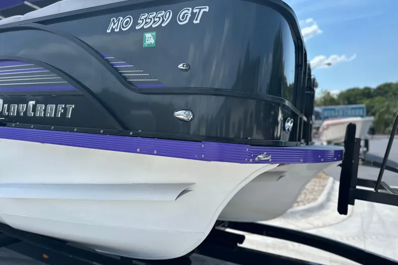 Slide: The Image of 2023 PlayCraft 2800 Extreme boat with sleek black and purple design on trailer. - 17