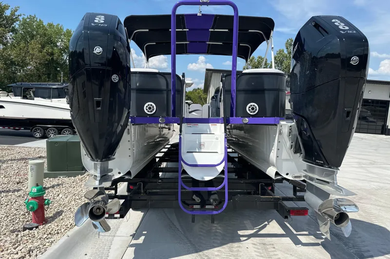 Slide: The Image of 2023 PlayCraft 2800 Extreme boat with dual outboard motors, parked on a trailer. - 3