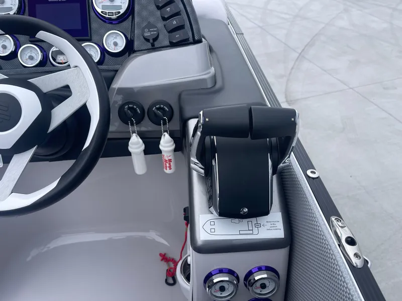 Slide: The Image of 2023 PlayCraft 3000 Infinity Extreme boat dashboard with steering wheel and controls. - 32