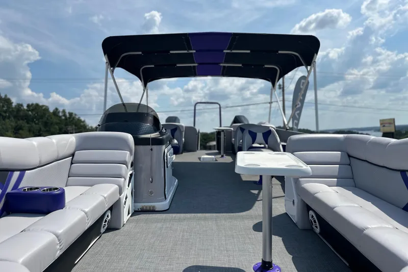 Slide: The Image of 2023 PlayCraft 2800 Extreme pontoon boat interior with seating and canopy under a blue sky. - 38