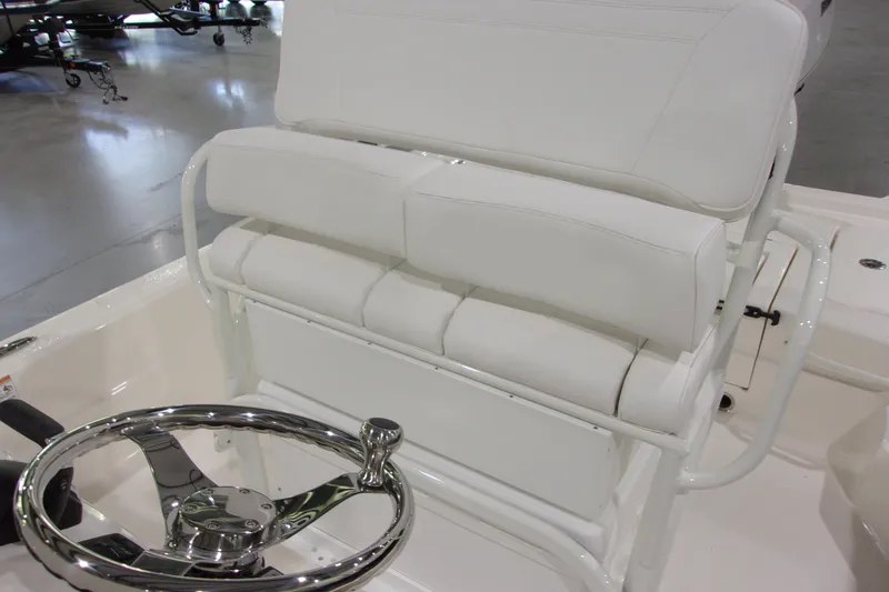 Slide: The Image of 2026 Skeeter 241 boat interior with white cushioned seating and chrome steering wheel. - 13