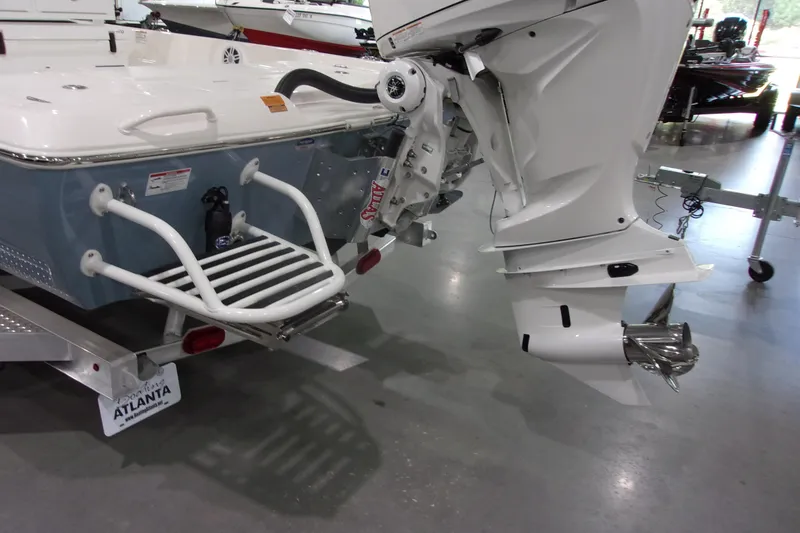 Slide: The Image of 2026 Skeeter 241 boat with outboard motor and swim platform in showroom. - 4