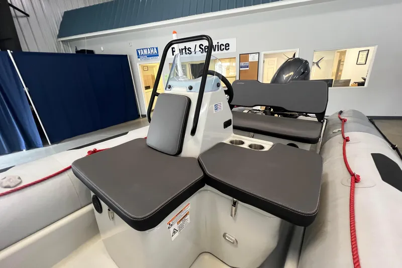 Slide: The Image of 2024 Zodiac Open 4.8 boat interior with seating and console in showroom. - 4