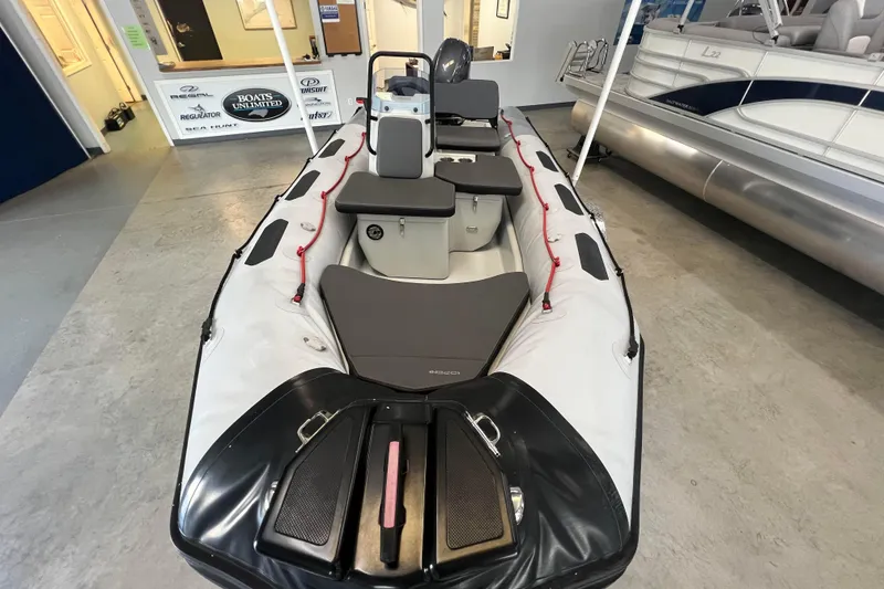 Slide: The Image of 2024 Zodiac Open 4.8 inflatable boat displayed indoors, showcasing seating and storage features. - 7