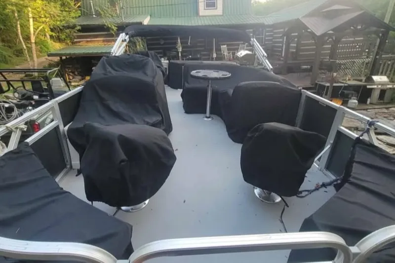 Slide: The Image of 2016 Avalon Catalina LSZ Fish boat with covered seating and table, docked near a cabin. - 10