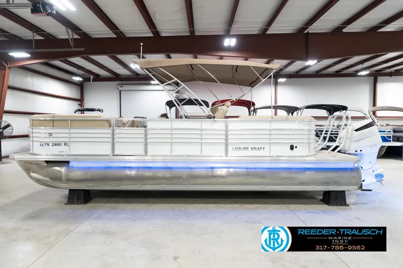 Slide: The Image of 2020 Leisurecraft 2435 LX pontoon boat in a showroom, featuring sleek design and modern amenities. - 10