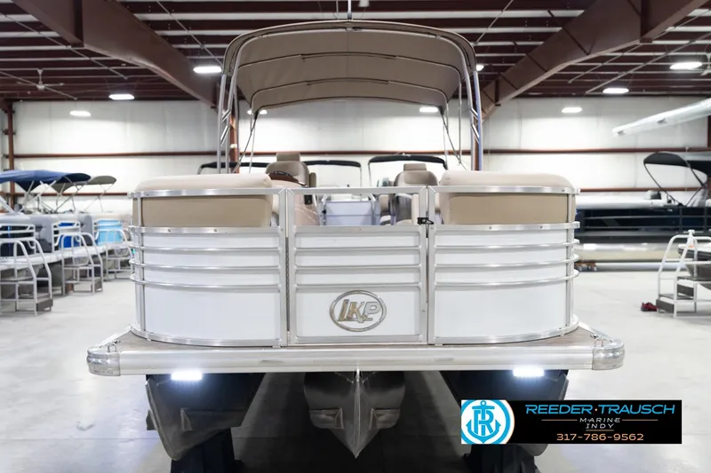Slide: The Image of 2020 Leisurecraft 2435 LX pontoon boat in showroom, featuring beige seating and canopy. - 4