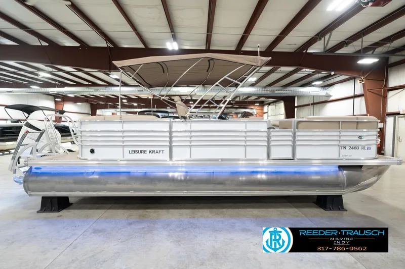 Slide: The Image of 2020 Leisurecraft 2435 LX pontoon boat in indoor showroom with canopy and blue underglow. - 6