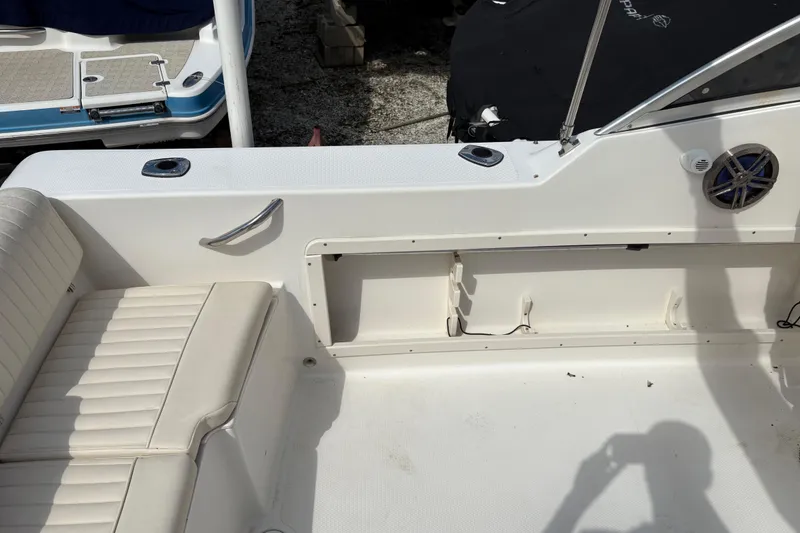 Slide: The Image of 2006 Mako 216 Dual Console boat interior with white seating and speaker. - 10
